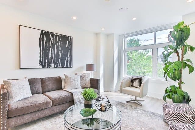 Helles Wohnzimmer mit Sofa, Kunstwerk und grossem Fenster